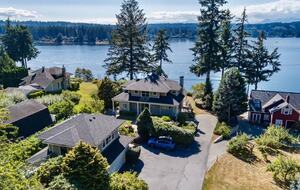 View of property with bay and Olympic Mountains