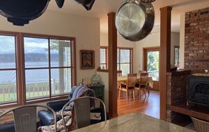 View from kitchen of seating area, woodstove, dining area
