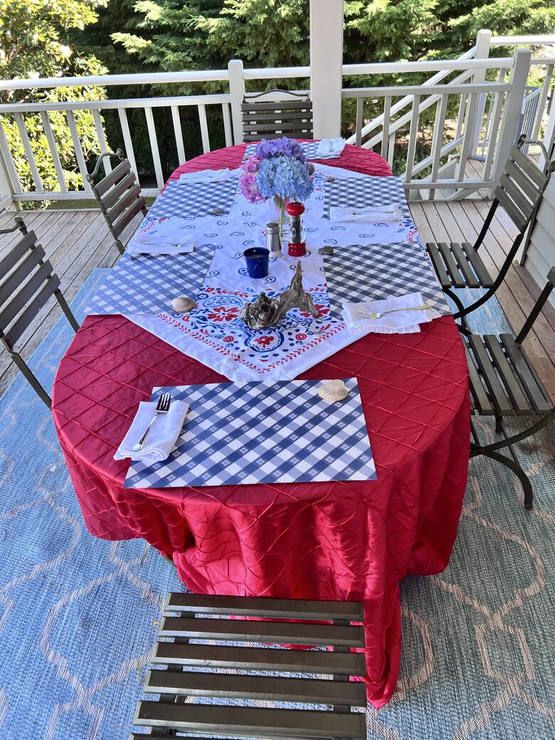 Outdoor bay view deck dining area, overlooks lawn