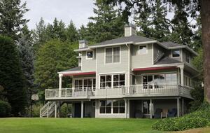 View of home and bay view decks from lawn area