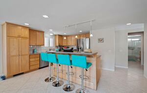 Intercambio de casas en Oxnard (California), isla de cocina con cuatro taburetes de color verde azulado