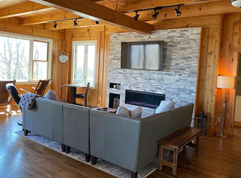 Home Exchange in Fairway, NC, living room with cozy sectional and fire
