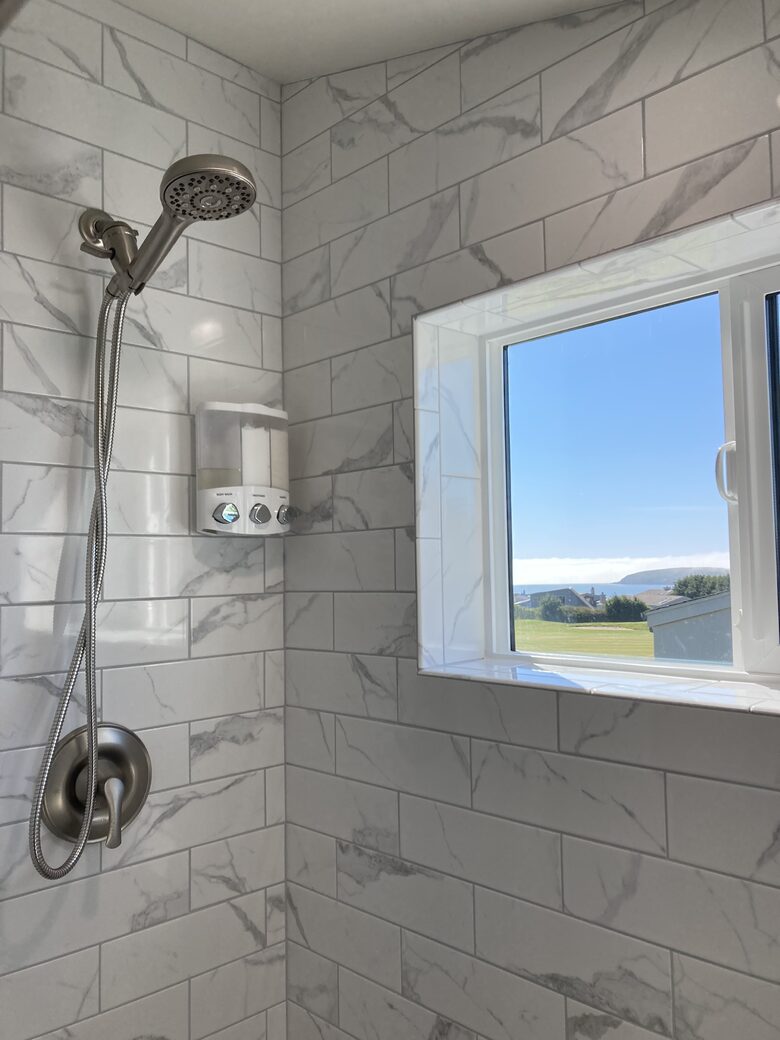 Full sized shower upstairs above garage with window view..