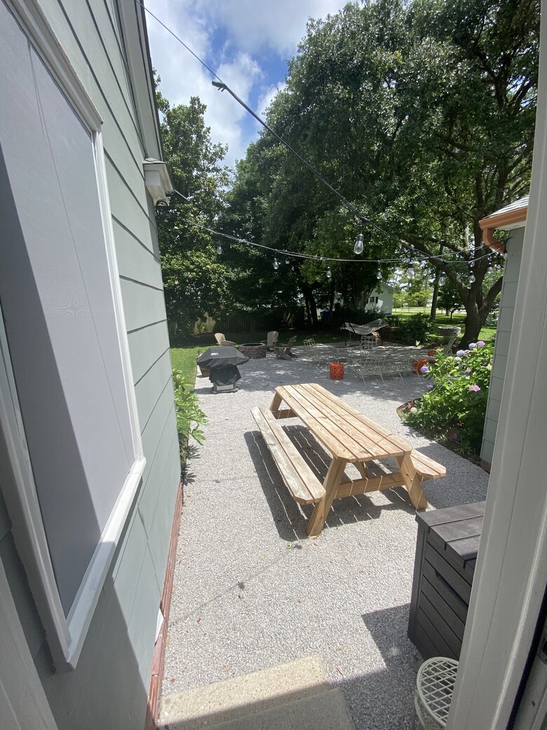 View of back garden patio from breezeway shaded by big old Oaks.