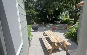 View of back garden patio from breezeway shaded by big old Oaks.
