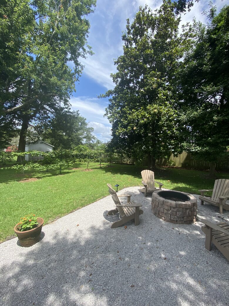 Firepit shaded by Oaks, a grape arbor, southern magnolia tree.