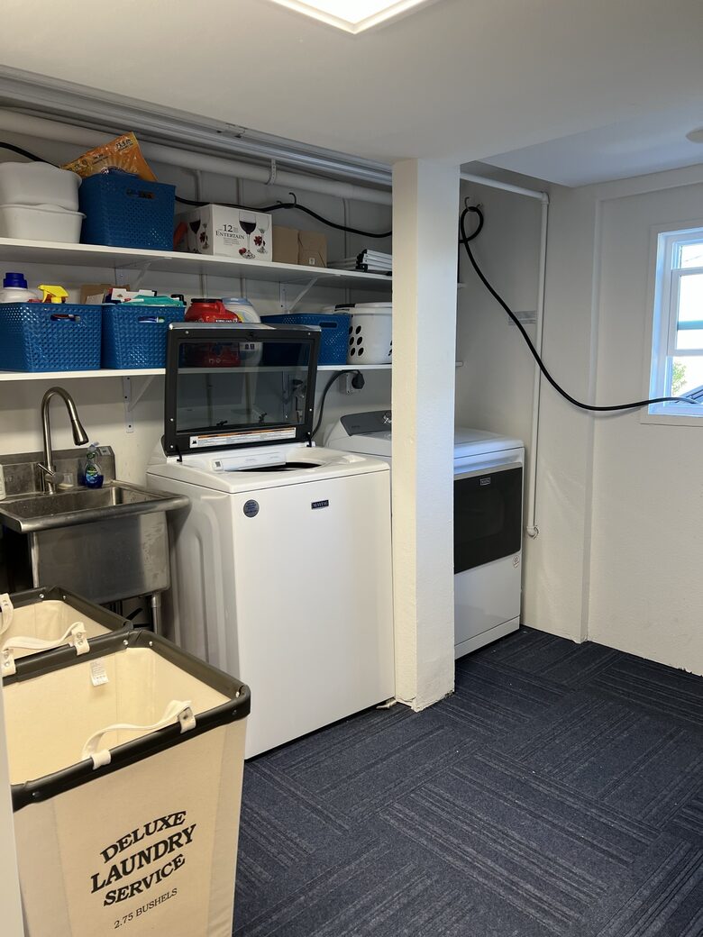 Laundry area inside converted garage for guest use.