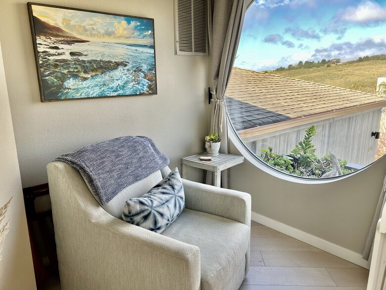 Reading area chair at landing with picturesque window.