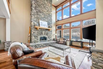 Grand living area with floor to sealing exposed rock gas fireplace.
