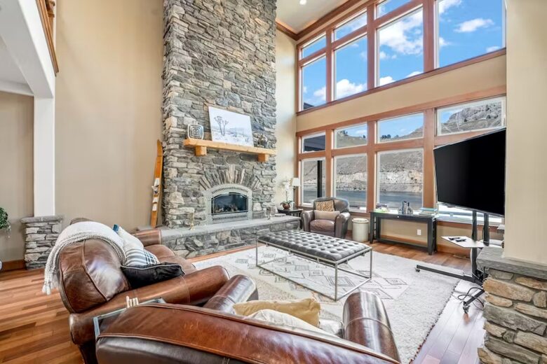 Grand living area with floor to sealing exposed rock gas fireplace.