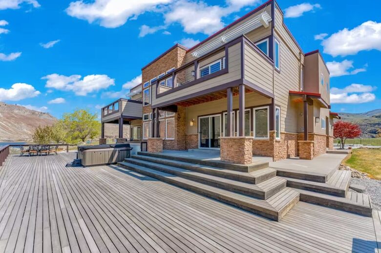 Expansive back deck with large hot tub, outdoor dining area, firepit.