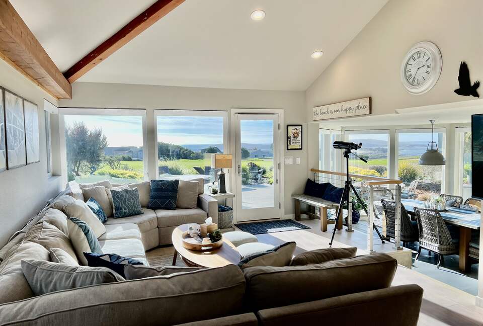Living room and dining room with fairway and ocean views beyond.