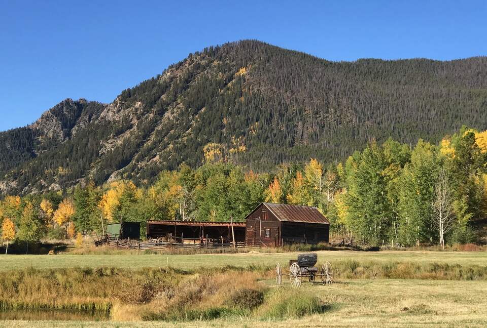 View from front porch across open space meadow and rustic barn