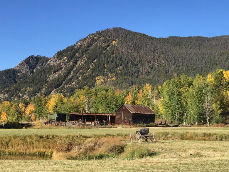 View from front porch across open space meadow and rustic barn