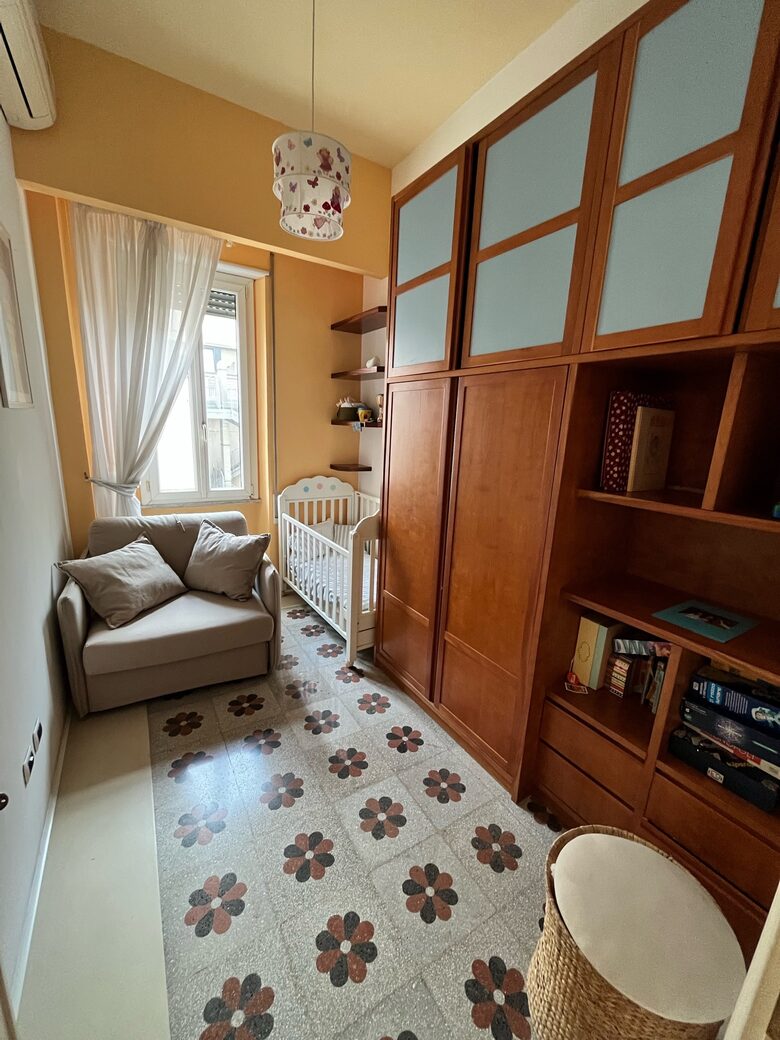 Small room with sofa bed and crib