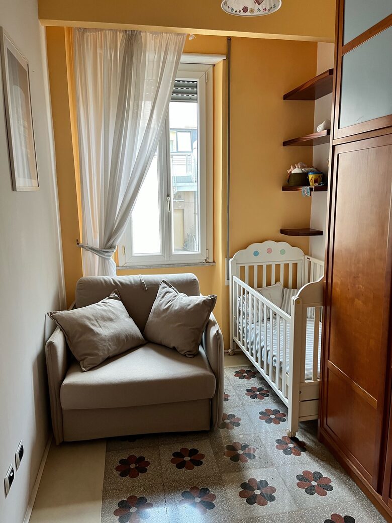 Small bedroom with single sofa bed and crib