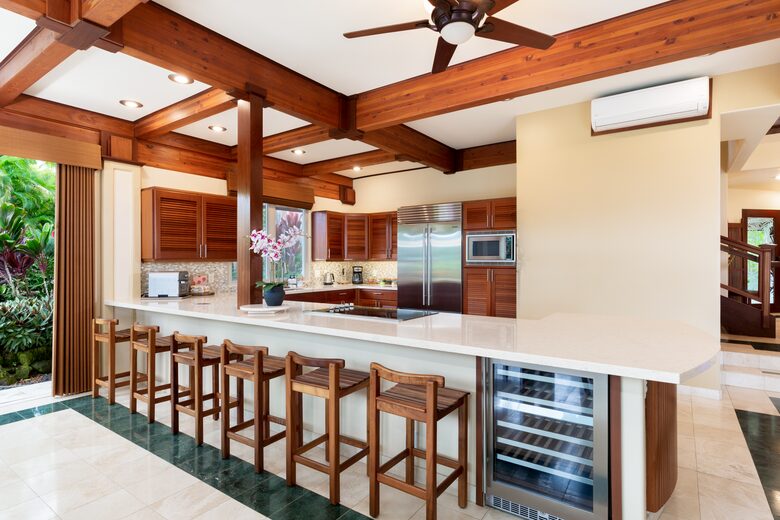 View of the kitchen with a wine fridge and bar stools