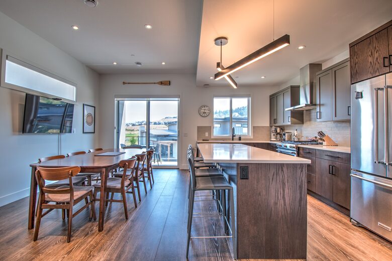 The sunny kitchen has a large television.