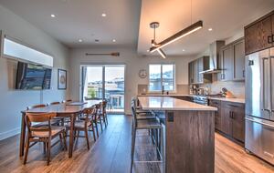 The sunny kitchen has a large television.
