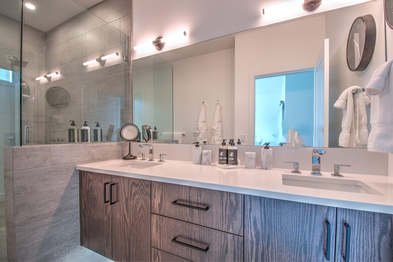 The master bathroom features two sinks and a glass shower