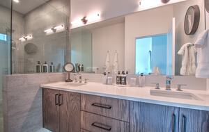 The master bathroom features two sinks and a glass shower