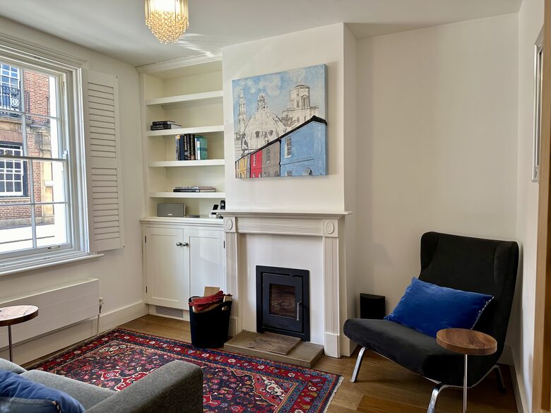 Second sitting room with original artwork and fireplace