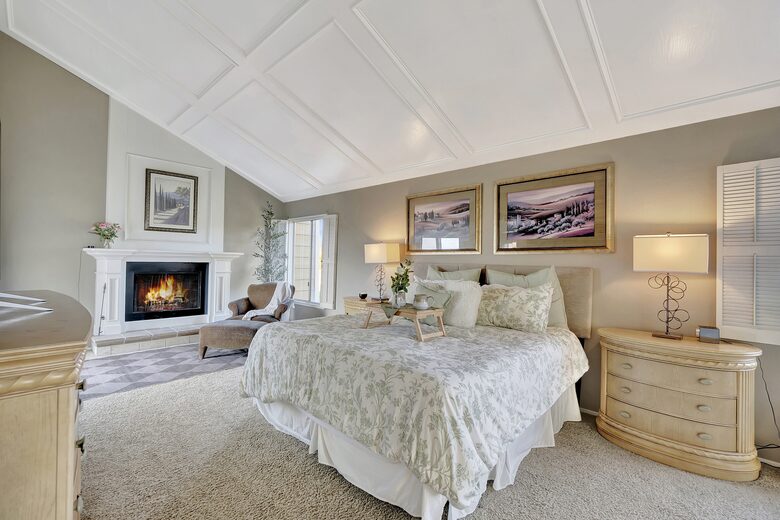 Primary bedroom with fireplace, sitting area and private balcony.