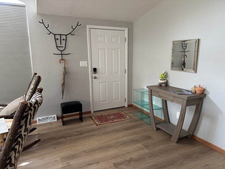 Front door with coat rack, stool, cubbies and umbrella