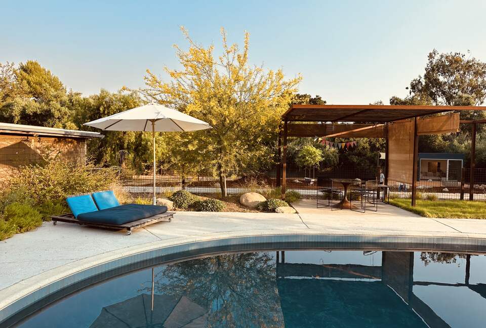 Shaded dining and lounge areas around pool