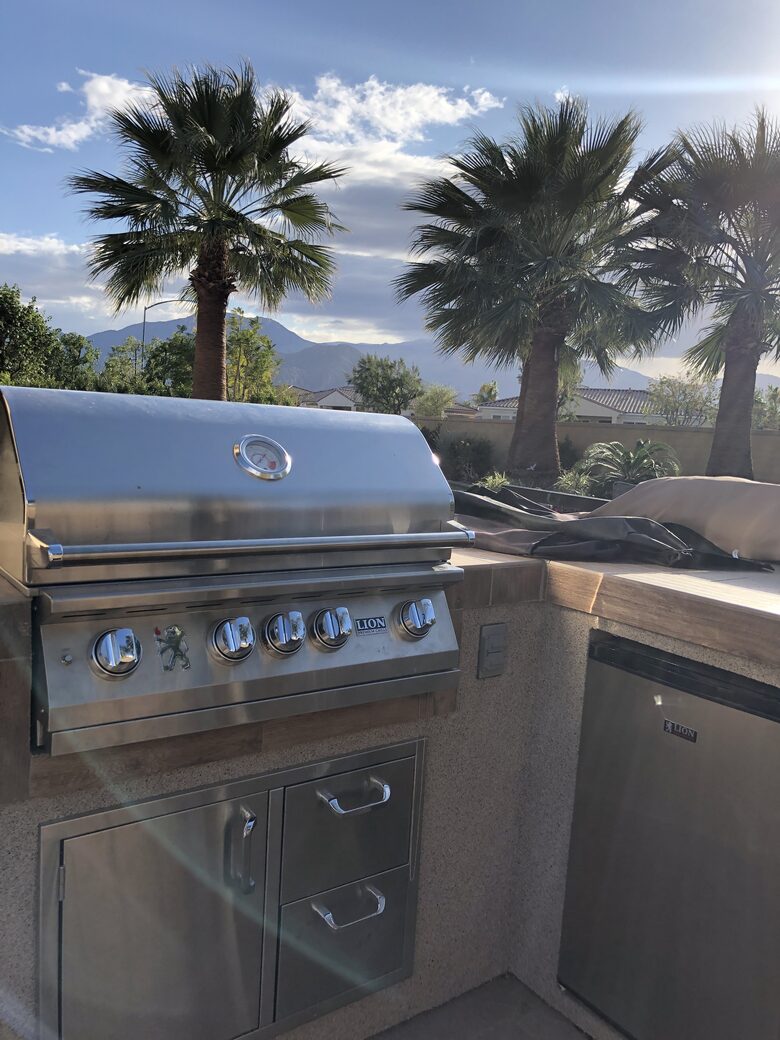 Large gas BBQ, entertainment center with barstools, fridge