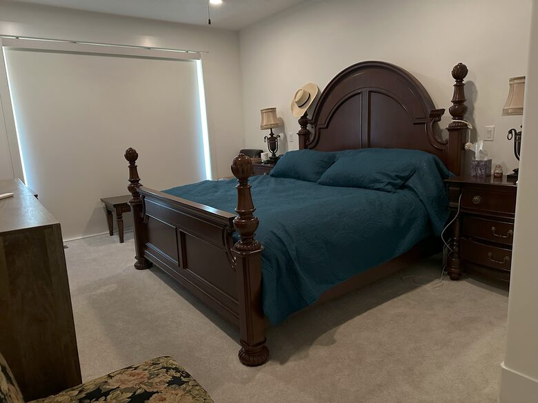 Primary bedroom with shades down beautiful views