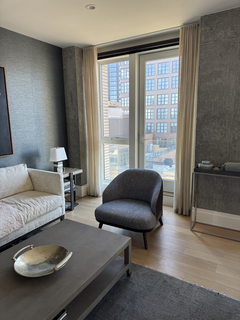 Living room on 1st fl. Floor-ceiling windows facing NYC, sunset views