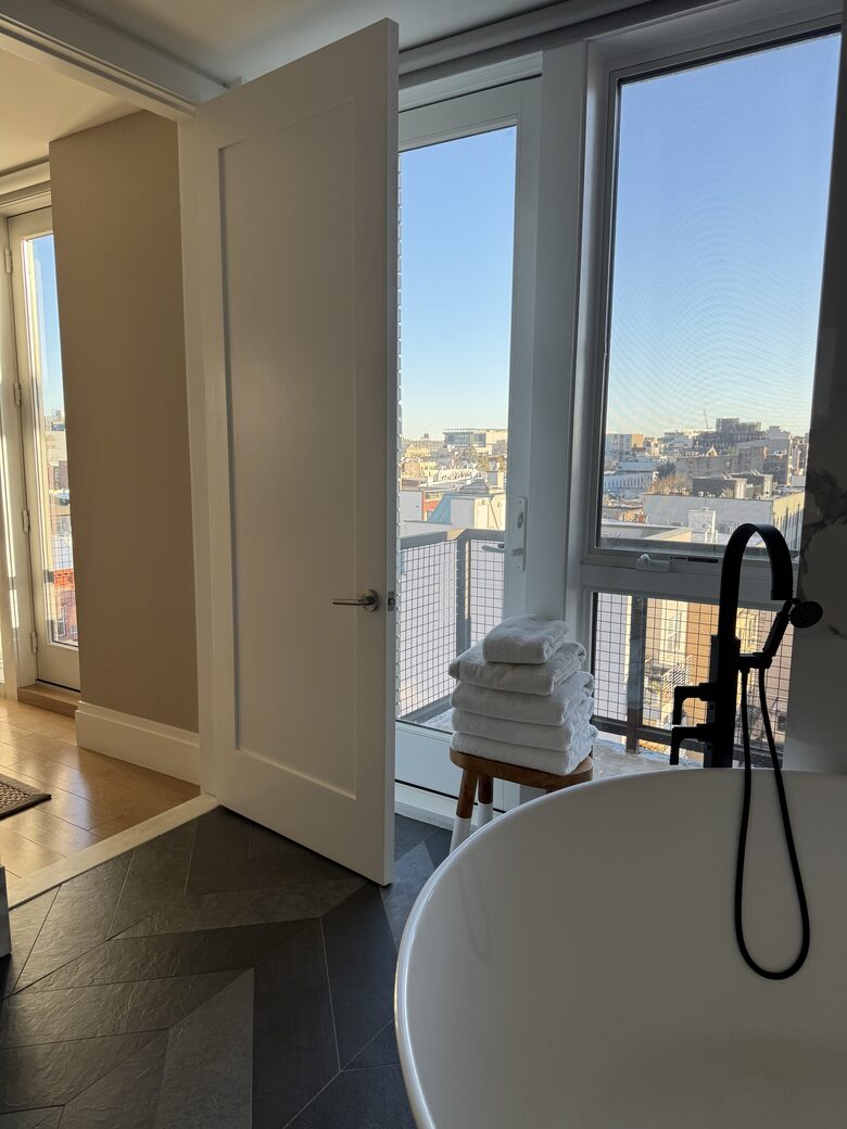 Primary bath 2nd fl. Floor-ceiling windows facing east, sunrise view