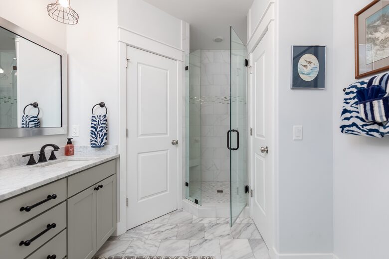 Upstairs primary bedroom with marble floors and custom tiled shower