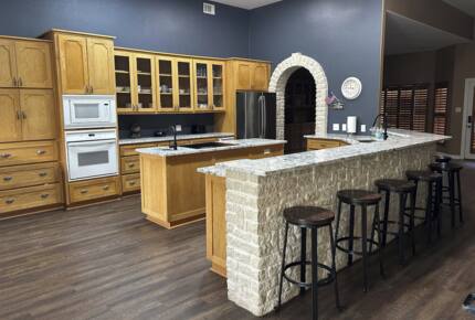 Kitchen with granite countertops, two ovens and ice maker