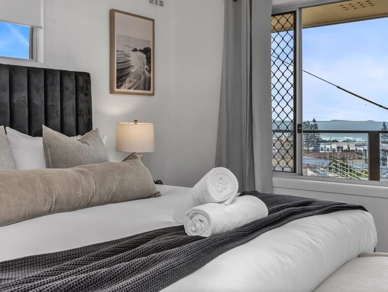 Bright bedroom with clean towels ready for guests
